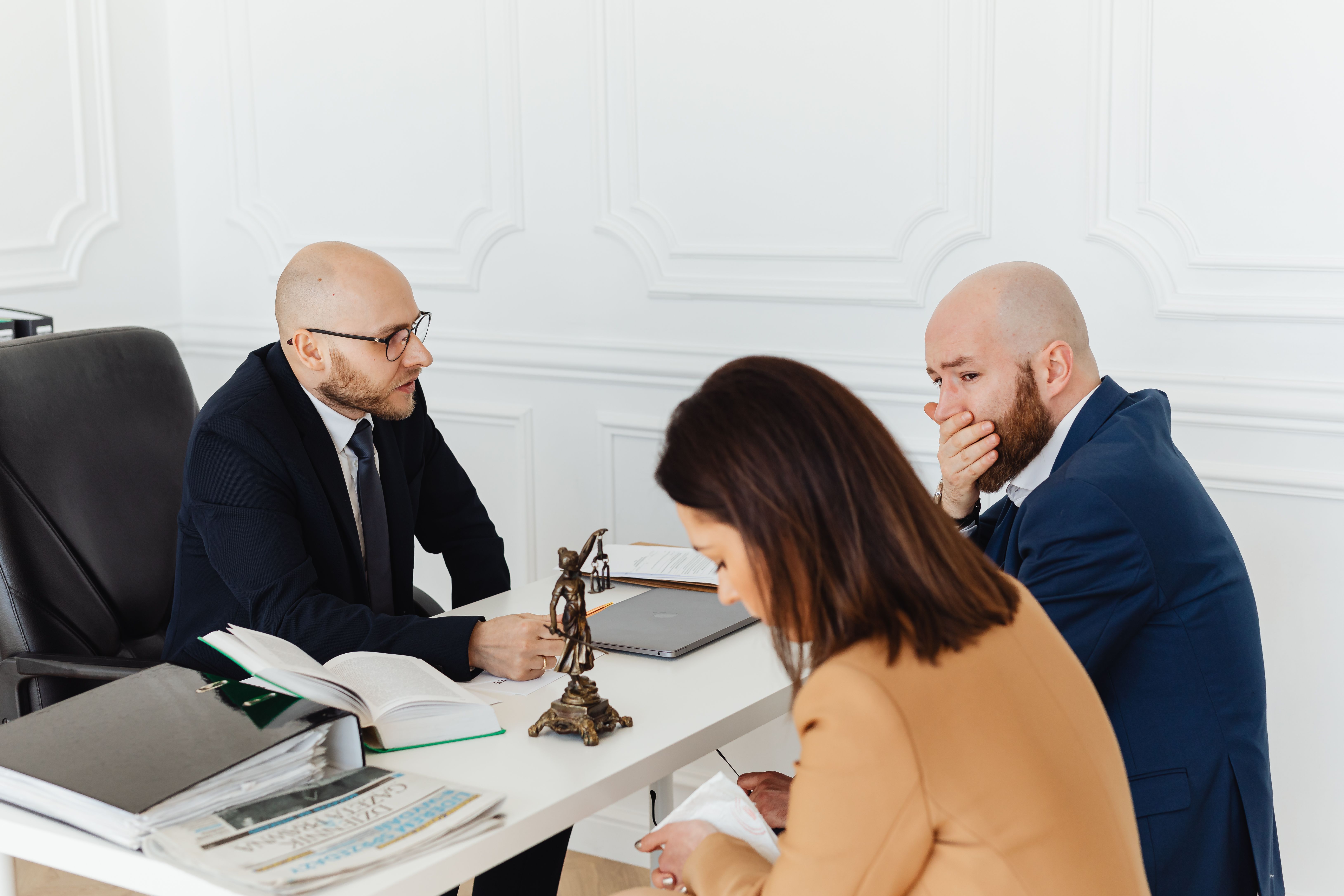 Lawyers conducting a serious legal consultation with clients in a professional office.