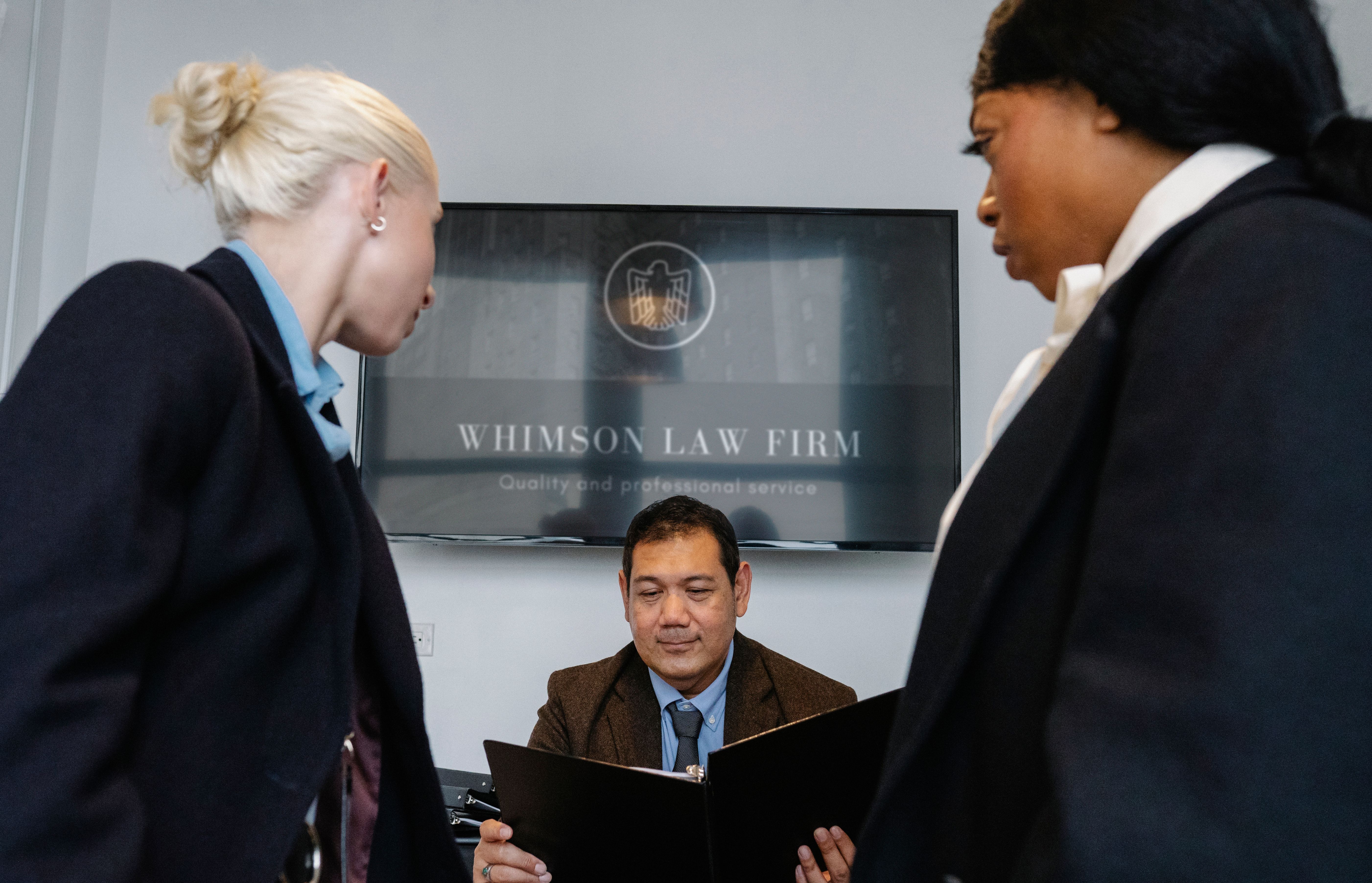 A diverse group of professionals discussing contract details together in a law office.