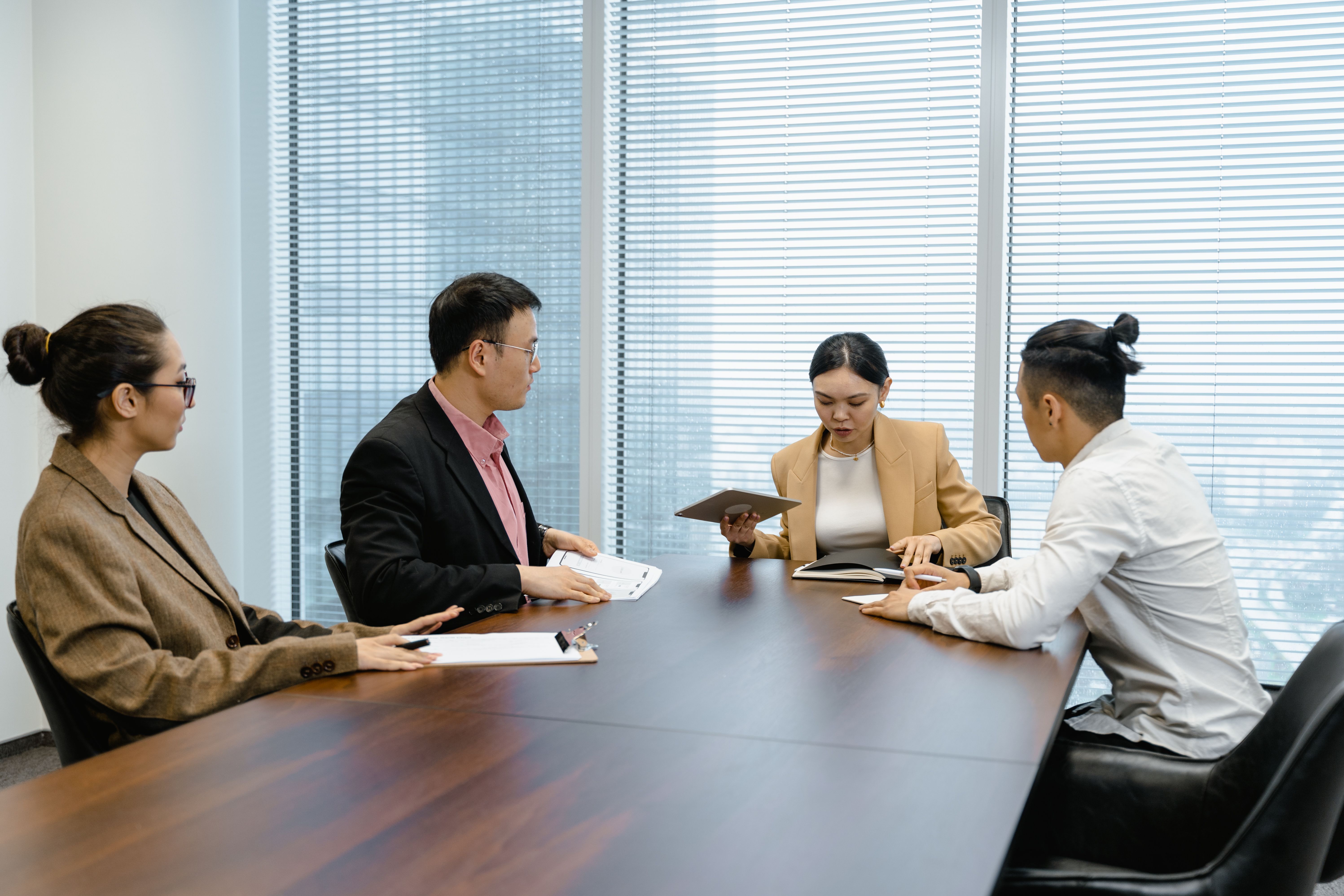 Diverse group of legal professionals in a boardroom discussing strategy for a large-scale claim