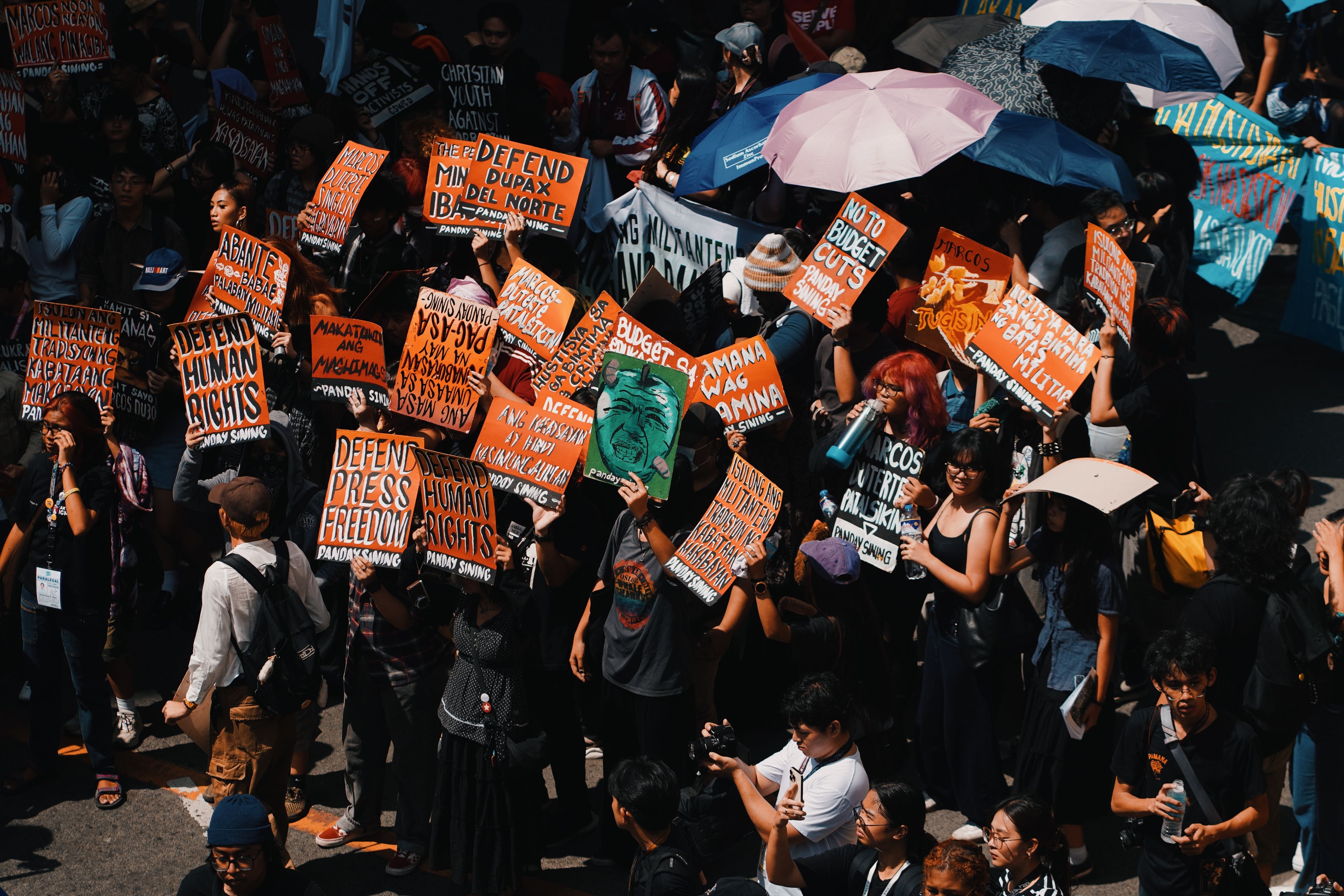 Crowd at a peaceful protest holding signs demanding human rights and freedom